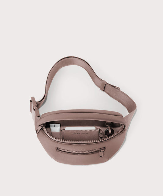 Dagne Dover Ace Fanny Pack in pink unzipped, exposing the interior pockets