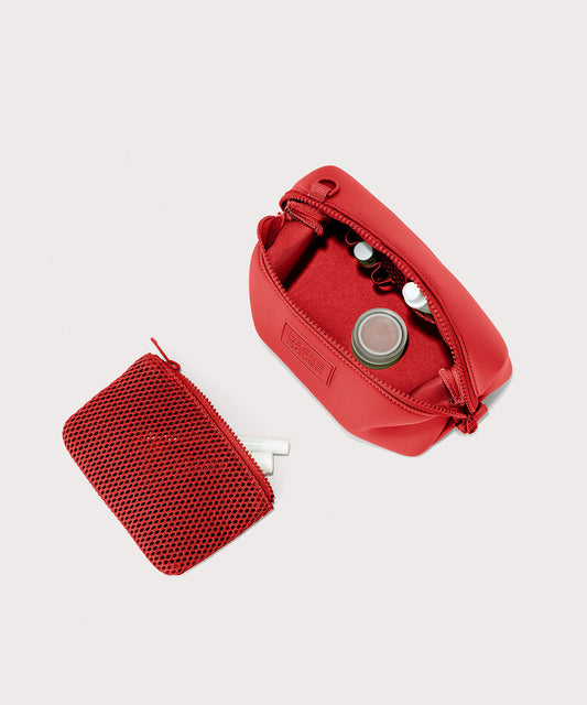Dagne Dover Small Hunter Toiletry Bag in a fiery, saturated red leaning toward orange unzipped and seen from above with the removable air mesh pouch alongside it.