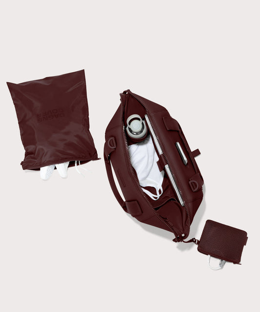 Dagne Dover Medium Landon Carryall in a deep brown with purple undertones unzipped, top down view.