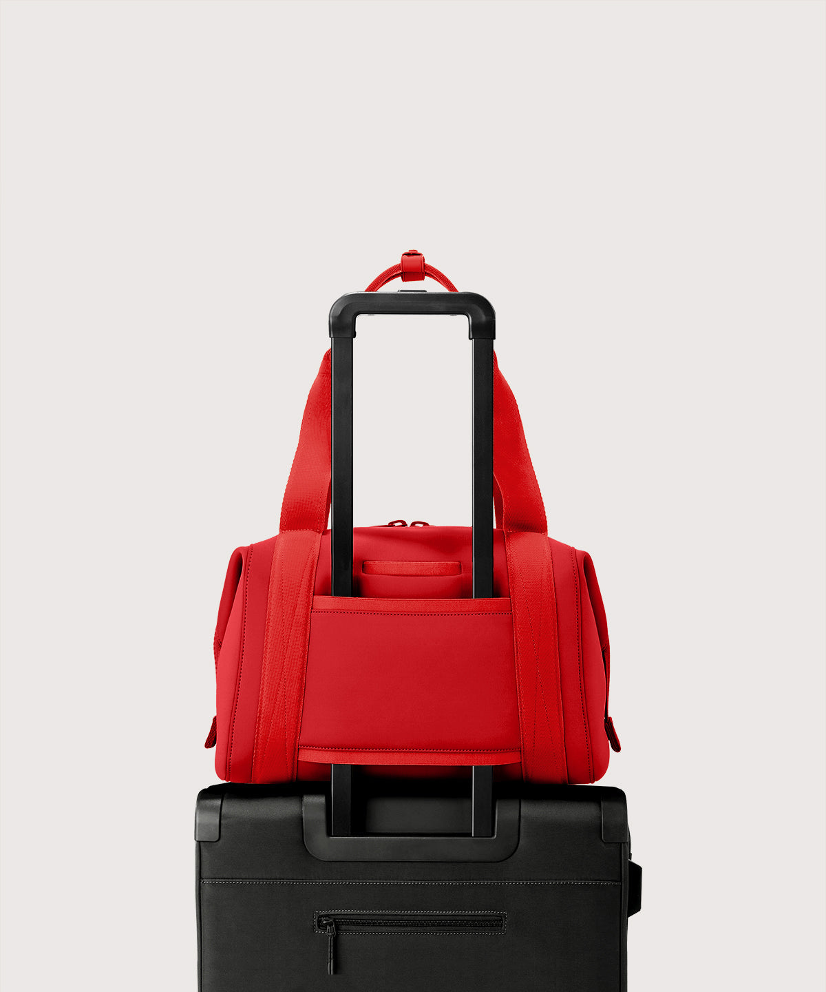 Dagne Dover Medium Landon Carryall in a fiery, saturated red leaning toward orange displaying luggage sleeve.