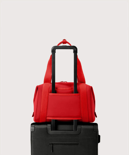 Dagne Dover Medium Landon Carryall in a fiery, saturated red leaning toward orange displaying luggage sleeve.