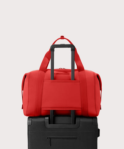 Dagne Dover Extra Large Landon Carryall in a fiery, saturated red leaning toward orange displaying luggage sleeve.