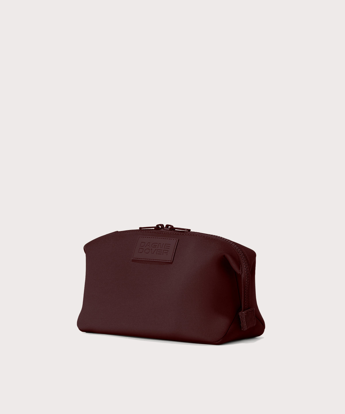 Dagne Dover Large Hunter Toiletry Bag in a deep brown with purple undertones seen from an angle.