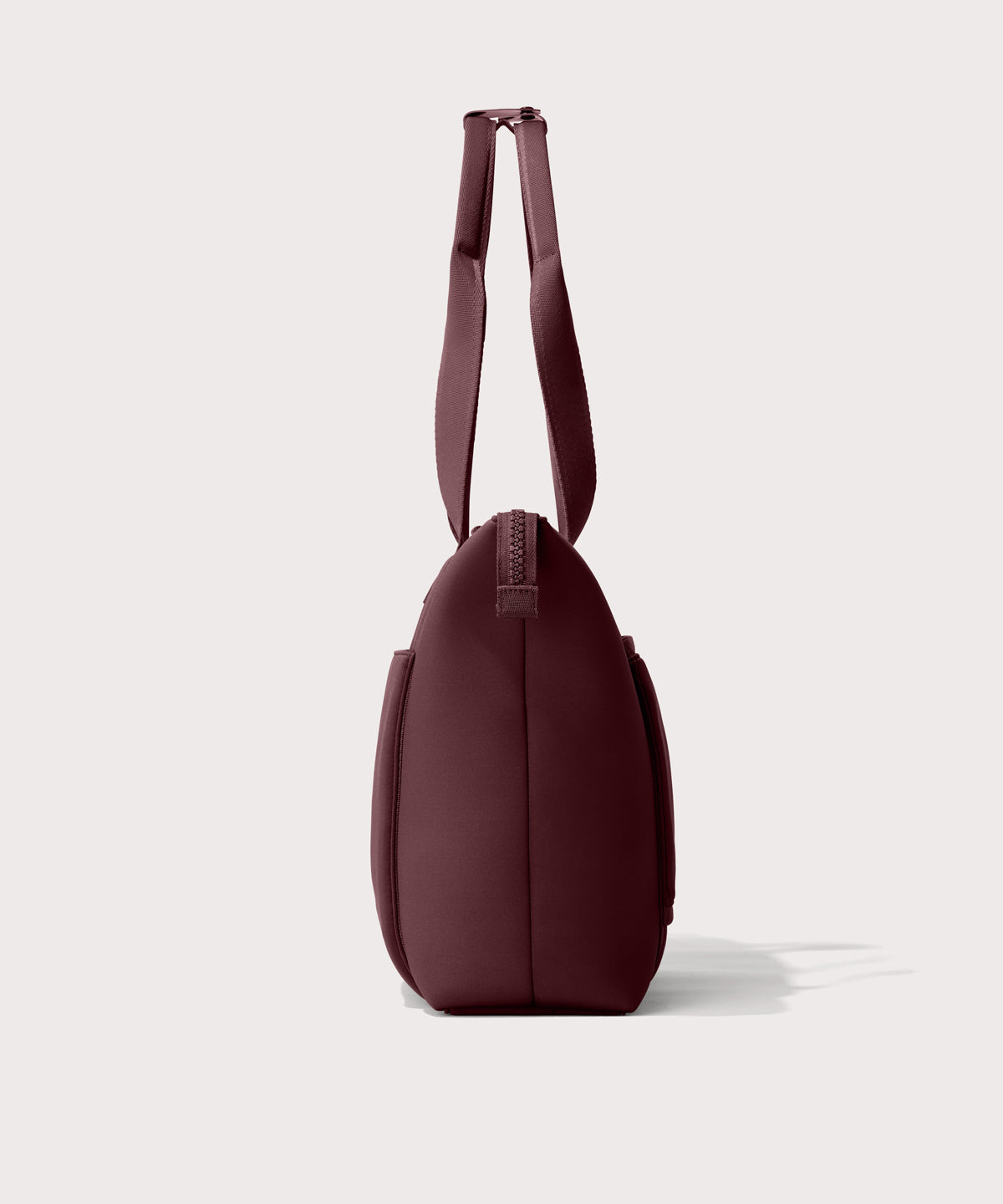 Tote bag in a deep brown with purple undertones reminiscent of maroon seen from the side view.
