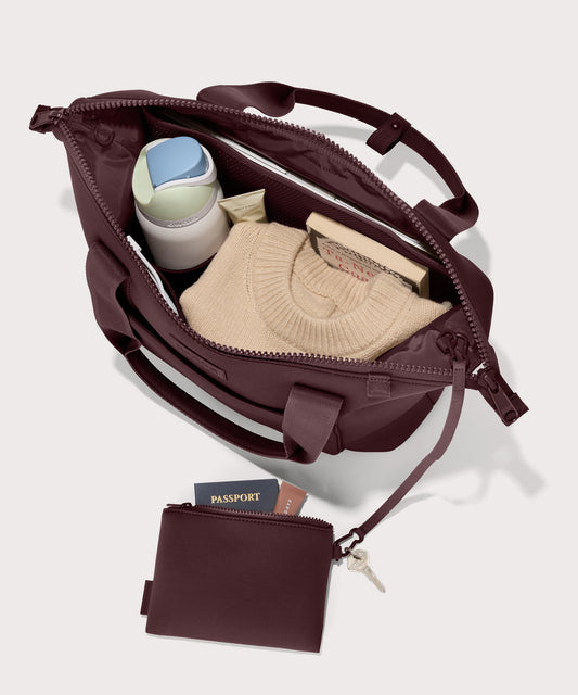 Tote bag in a deep brown with purple undertones reminiscent of maroon seen from the top down view showing interior mesh pouch.