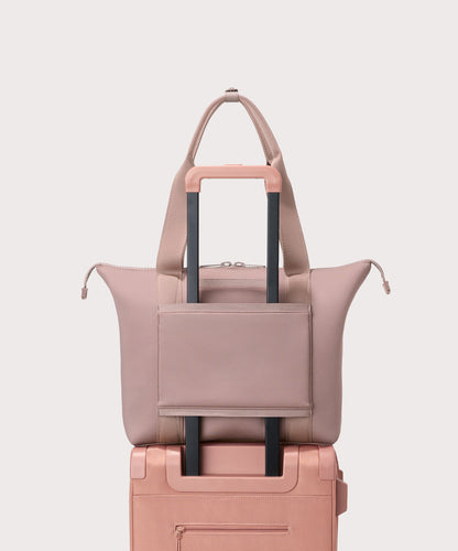 Tote bag in a pink seen from the back view on suitcase.