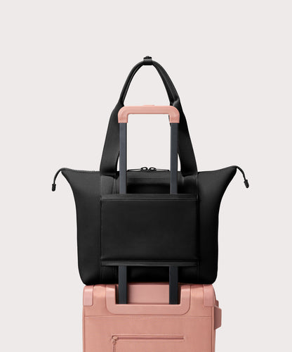 Tote bag in a black seen from the back view on suitcase.