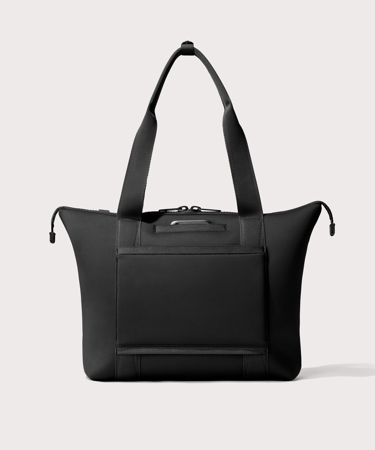 Tote bag in a black seen from the back view showing phone pocket.’