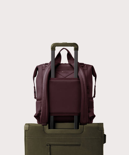 Dagne Dover Large Indi Diaper Backpack in a deep brown with purple undertones on luggage showing the neoprene luggage sleeve.