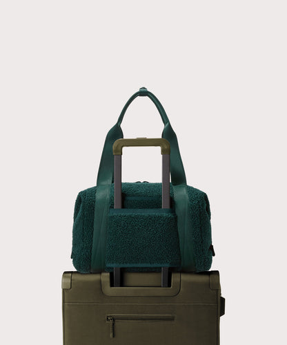 Medium landon carryall in a saturated, jewel-toned deep green with bold blue undertones.. displaying luggage sleeve