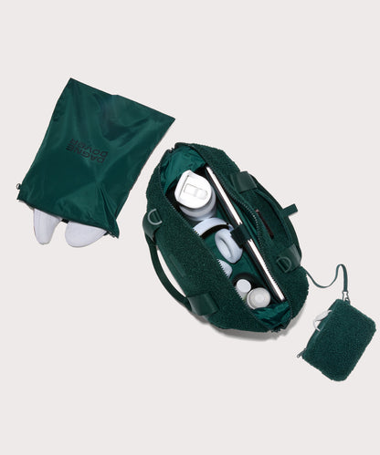 Medium landon carryall in a saturated, jewel-toned deep green with bold blue undertones. . unzipped, top down view. In a Faux Shearling a soft, wool-like plush made with recycled materials