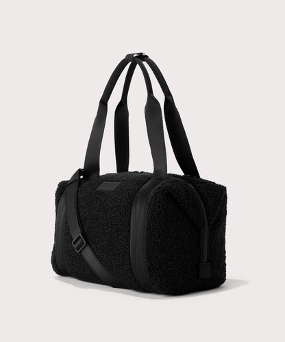 Medium landon carryall in a black. side angle view In a Faux Shearling a soft, wool-like plush made with recycled materials