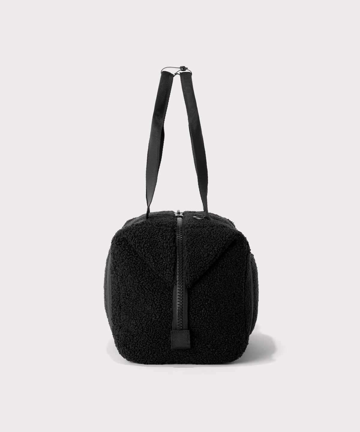 Medium landon carryall in a black., side view In a Faux Shearling a soft, wool-like plush made with recycled materials