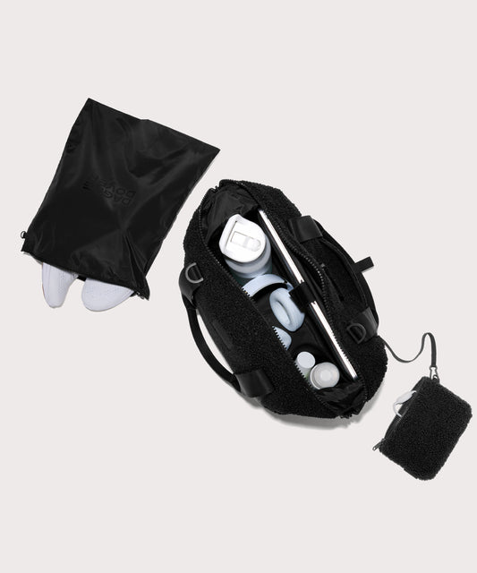 Medium landon carryall in a black. . unzipped, top down view. In a Faux Shearling a soft, wool-like plush made with recycled materials