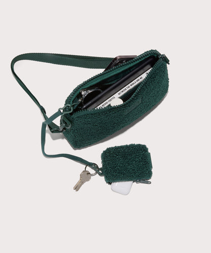 nora shoulder bag in a saturated, jewel-toned deep green with bold blue undertones . unzipped, top down view. In a Faux Shearling a soft, wool-like plush made with recycled materials