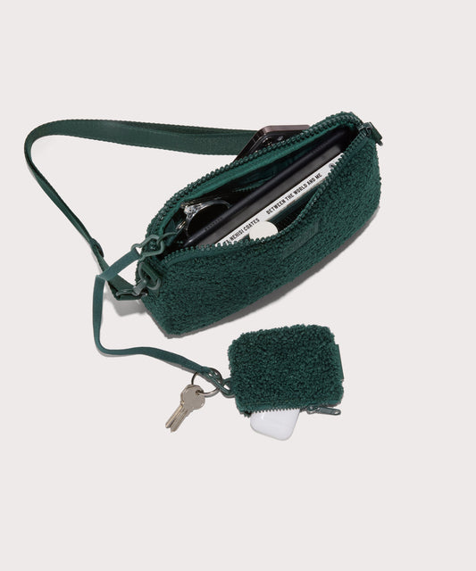 nora shoulder bag in a saturated, jewel-toned deep green with bold blue undertones . unzipped, top down view. In a Faux Shearling a soft, wool-like plush made with recycled materials