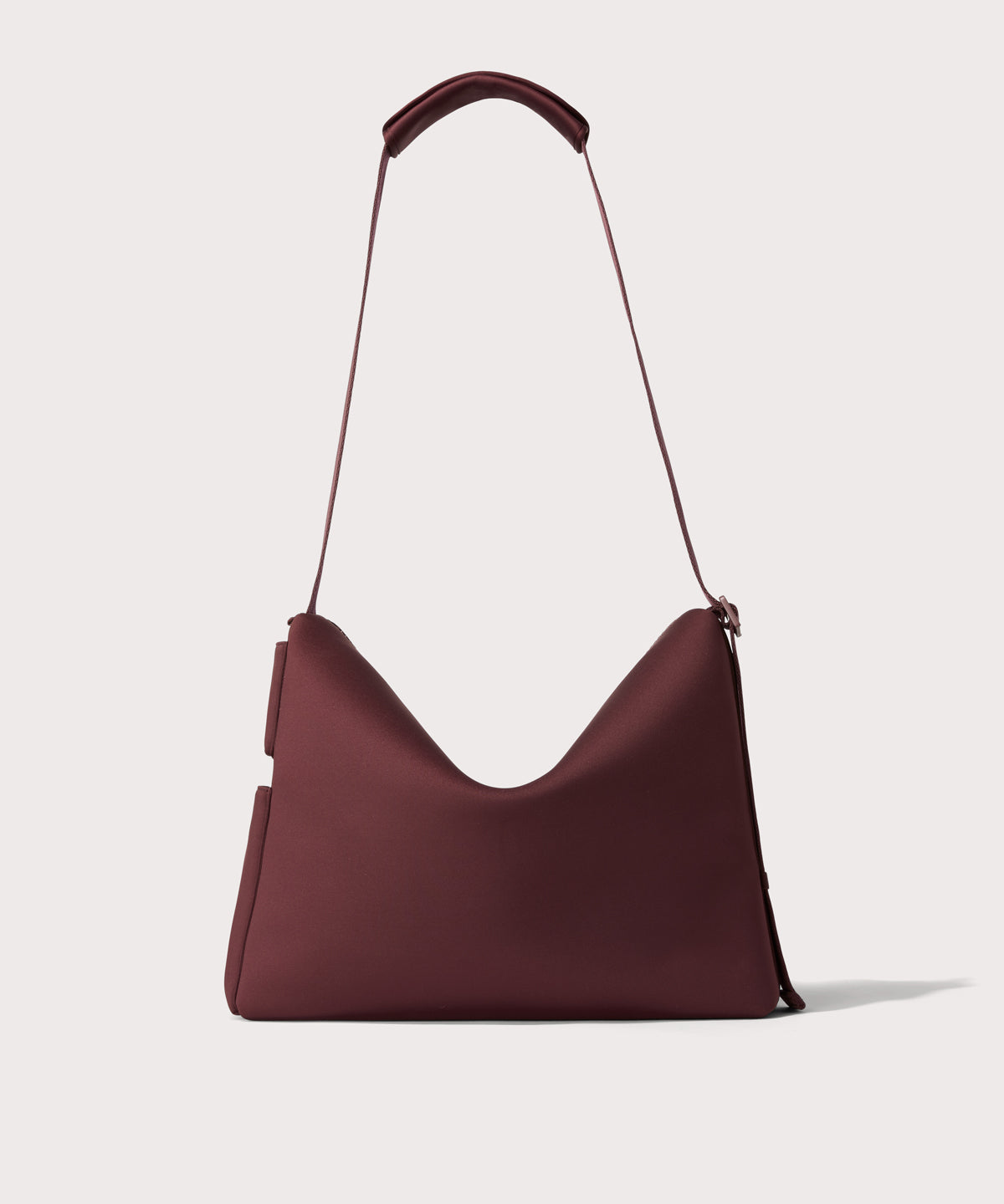 Large Shoulder bag in a deep brown with purple undertones reminiscent of maroon seen from the back view showing phone pocket.