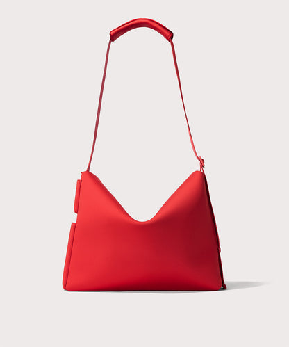 Red shoulder bag with a unique curved shape and a thin strap