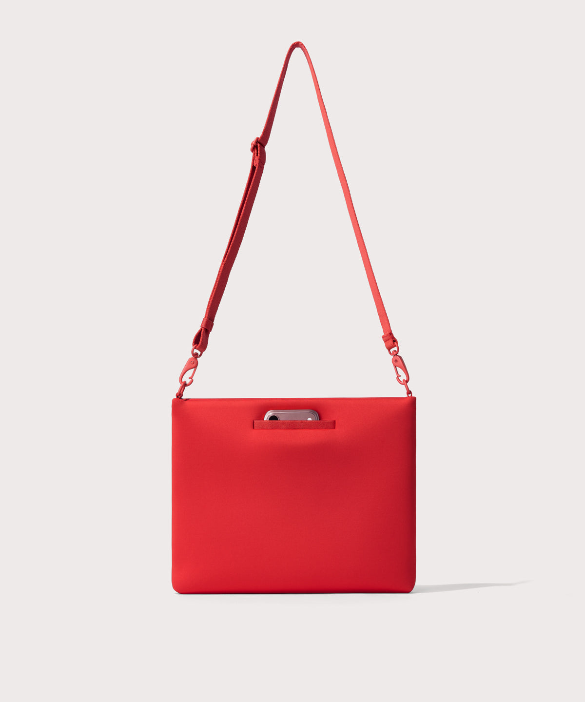 14 inch laptop shoulder bag in a fiery, saturated red leaning toward orange seen from the back view showing phone pocket.