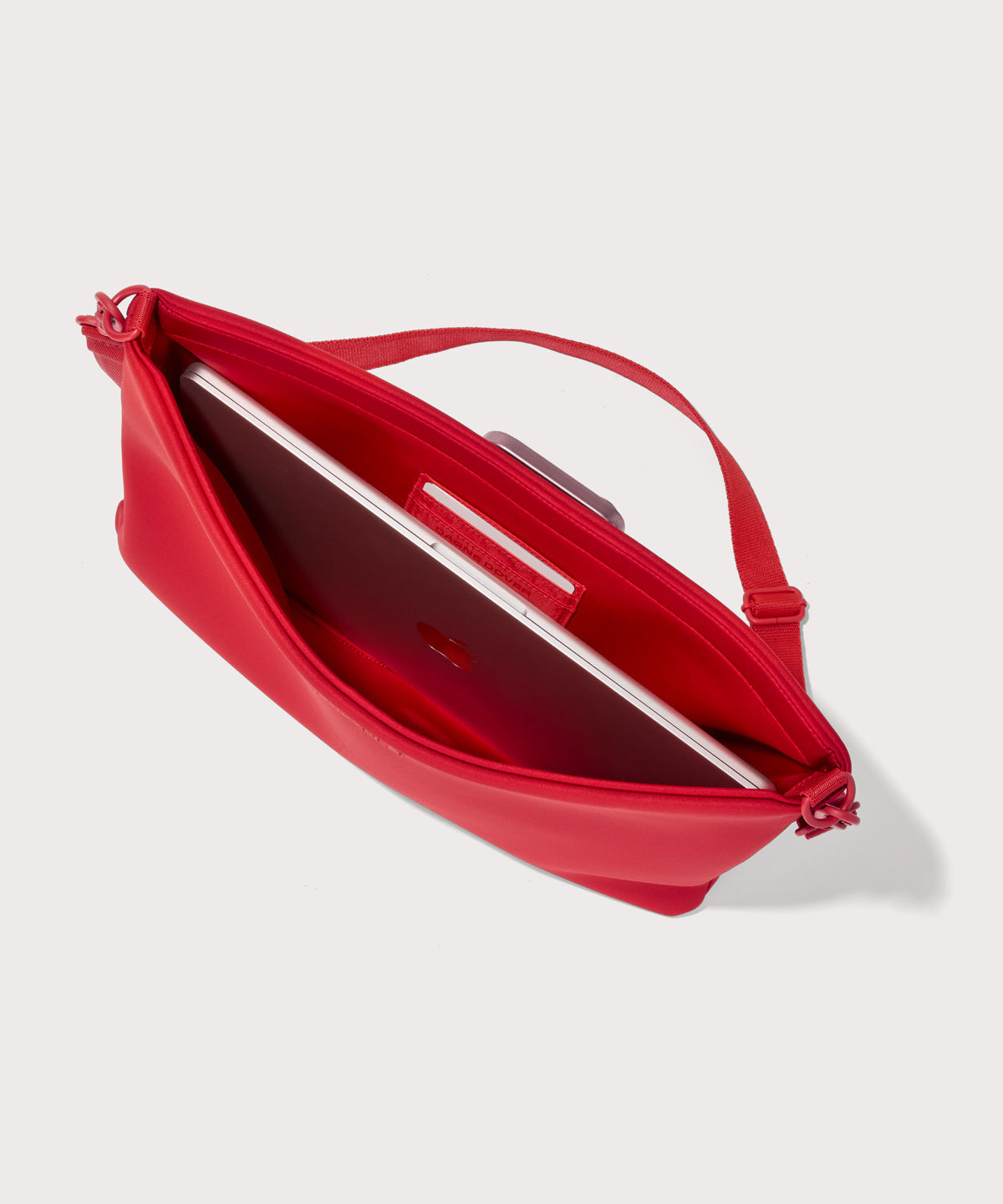 16 inch laptop shoulder bag in a fiery, saturated red leaning toward orange seen from the top down view showing interior.