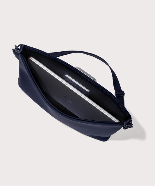 16 inch laptop shoulder bag in a navy blue seen from the top down view showing interior.