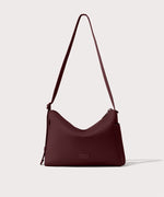 Shoulder bag in a deep brown with purple undertones reminiscent of maroon seen from the front view.