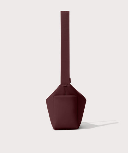 Shoulder bag in a fiery, deep brown with purple undertones reminiscent of maroon seen from the side view showing phone pocket.
