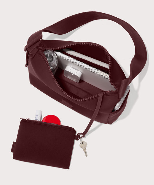 Shoulder bag in a A deep brown with purple undertones reminiscent of maroon seen from the top down view showing interior mesh pouch.