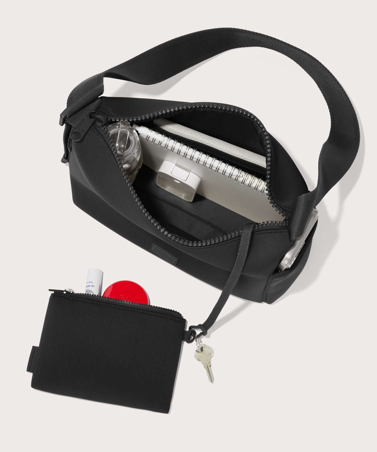 Shoulder bag in a black seen from the top down view showing interior mesh pouch.