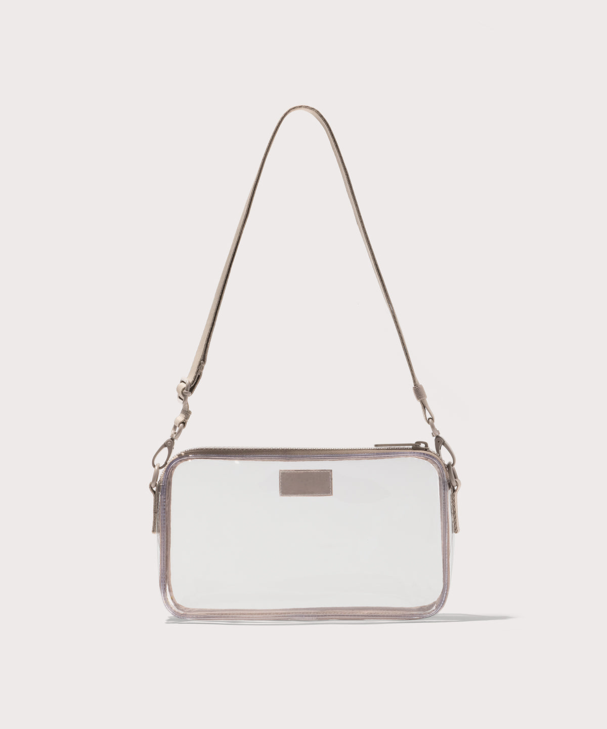 Clear crossbody bag with a beige strap on a white background. Stadium compliant.
