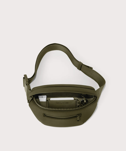 Dagne Dover Ace Fanny Pack in dark green unzipped, exposing the interior pockets