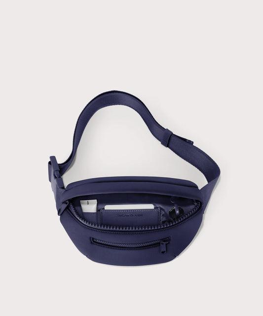 Dagne Dover Ace Fanny Pack in dark blue unzipped, exposing the interior pockets