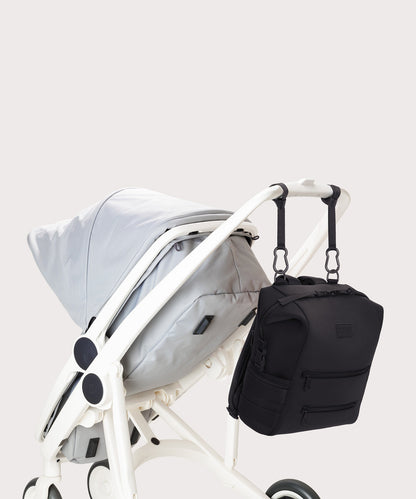 Dagne Dover medium Indi Diaper Backpack in black attached to a stroller.