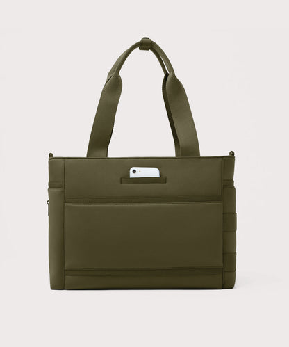 Dagne Dover large Wade Diaper Tote in dark green seen from the back with a phone in the exterior phone pocket.