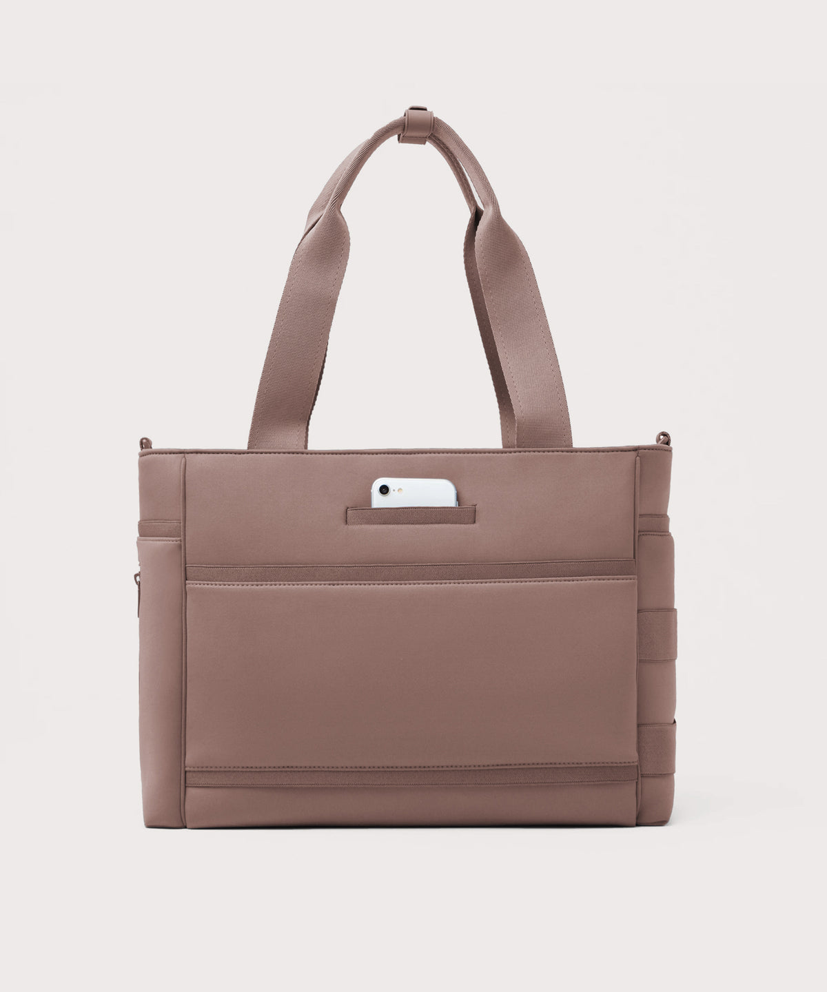 Dagne Dover large Wade Diaper Tote in pink seen from the back with a phone in the exterior phone pocket.