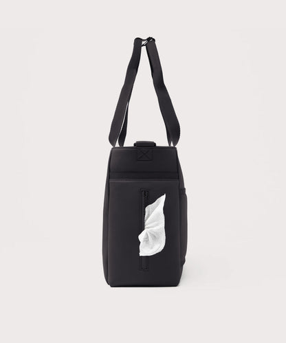 Dagne Dover large Wade Diaper Tote in black seen from the side, with a wet wipe poking out of the slip pocket.
