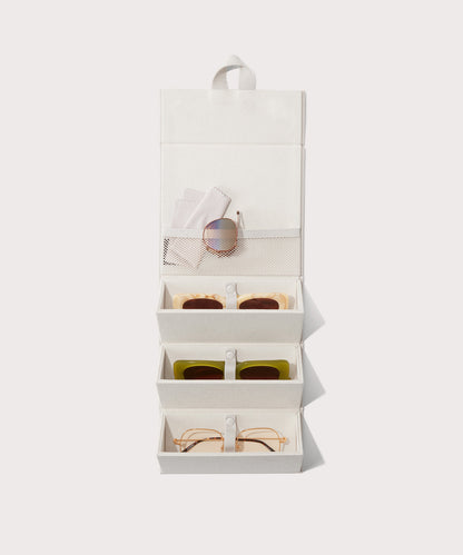 Dagne Dover Remi foldable glasses holder in white hung up and holding glasses.