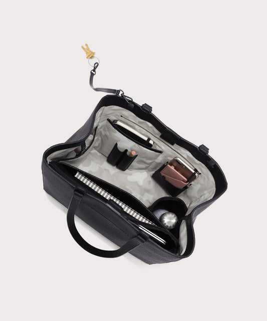 hover - Dagne Dover large Allyn Tote in black with objects inside the interior pockets.