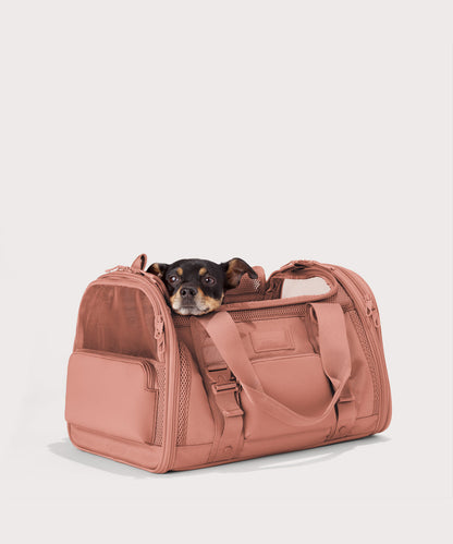 Dagne Dover Large Kyoto Pet Carrier in a warm dust pink seen from an angle with a dog inside the carrier. Caption: Ocho is a 16-lb Chihuahua mix