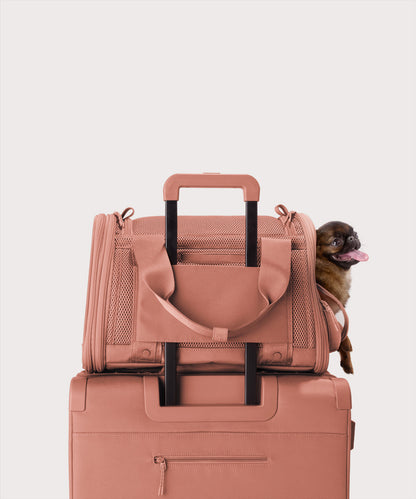 Dagne Dover small Kyoto Pet Carrier in a warm dust pink displaying luggage sleeve with a dog inside the carrier.