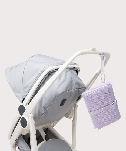 Dagne Dover Joey Changing Kit in a soft purple with grey undertones strapped to the handle of a stroller.