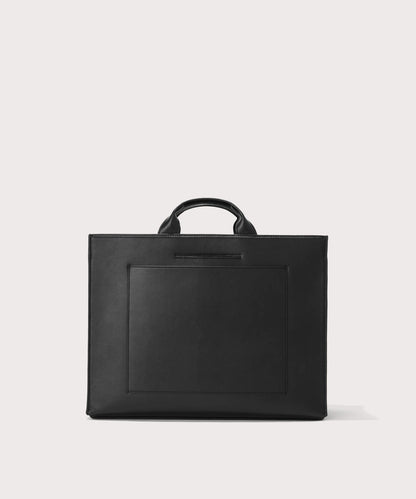Dagne Dover large vegan Daily Tote in black revealing the exterior phone pocket and exterior luggage sleeve.