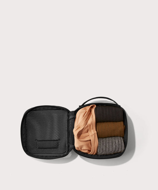 small Roma packing cube in carbon black open with jeans inside