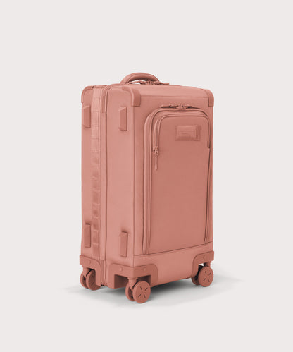 ¾ front view of Seattle carry-on rolling luggage 23.5” in warm dust pink with front flap opened. Caption: Interior slip pocket fits most 16" laptops