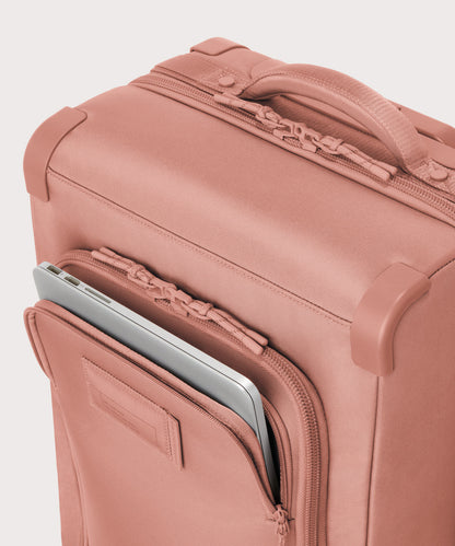 Top down of Seattle carry-on rolling luggage 23.5” in warm dust pink with front flap opened.