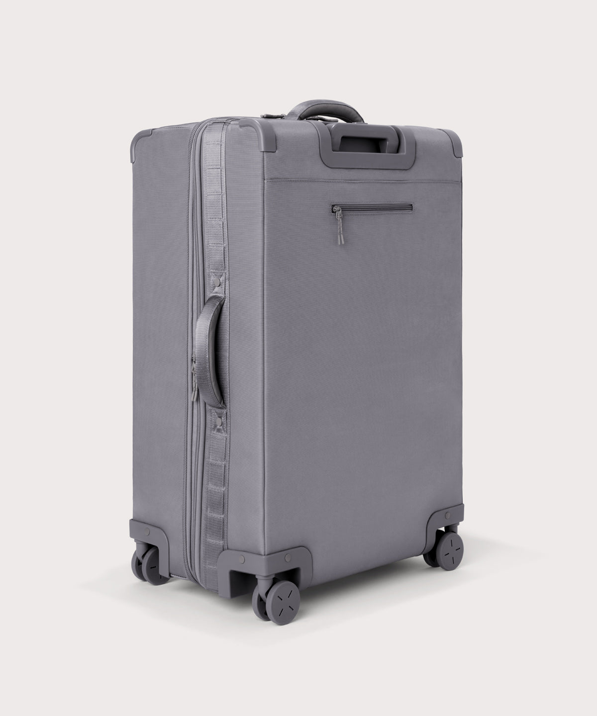 3/4 back view of Sydney checked rolling luggage 28.5” in light grey showing side handle and back zippered phone/passport pocket