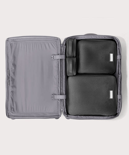 Top down of Sydney checked rolling luggage 28.5” in light grey with interior divider zipped and packing cubes packed into the right side.