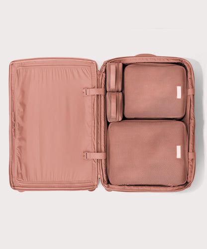 Top down of Sydney checked rolling luggage 28.5” in warm dust pink with interior divider zipped and packing cubes packed into the right side.
