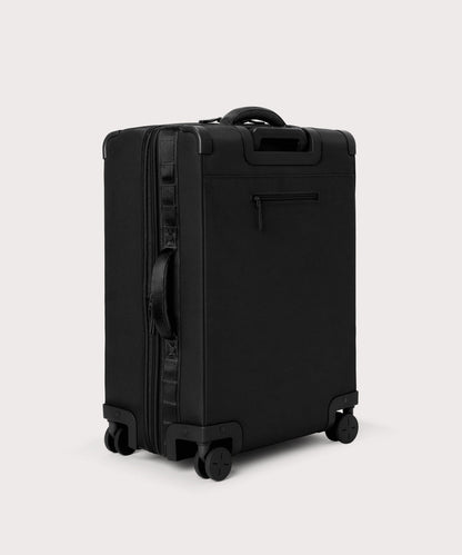 3/4 back view of Sydney checked rolling luggage 25" in black showing side handle and back zippered phone/passport pocket