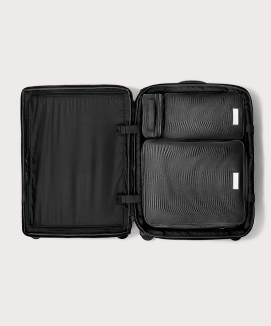 Top down of Sydney checked rolling luggage 25" in black with interior divider zipped and packing cubes packed into the right side.